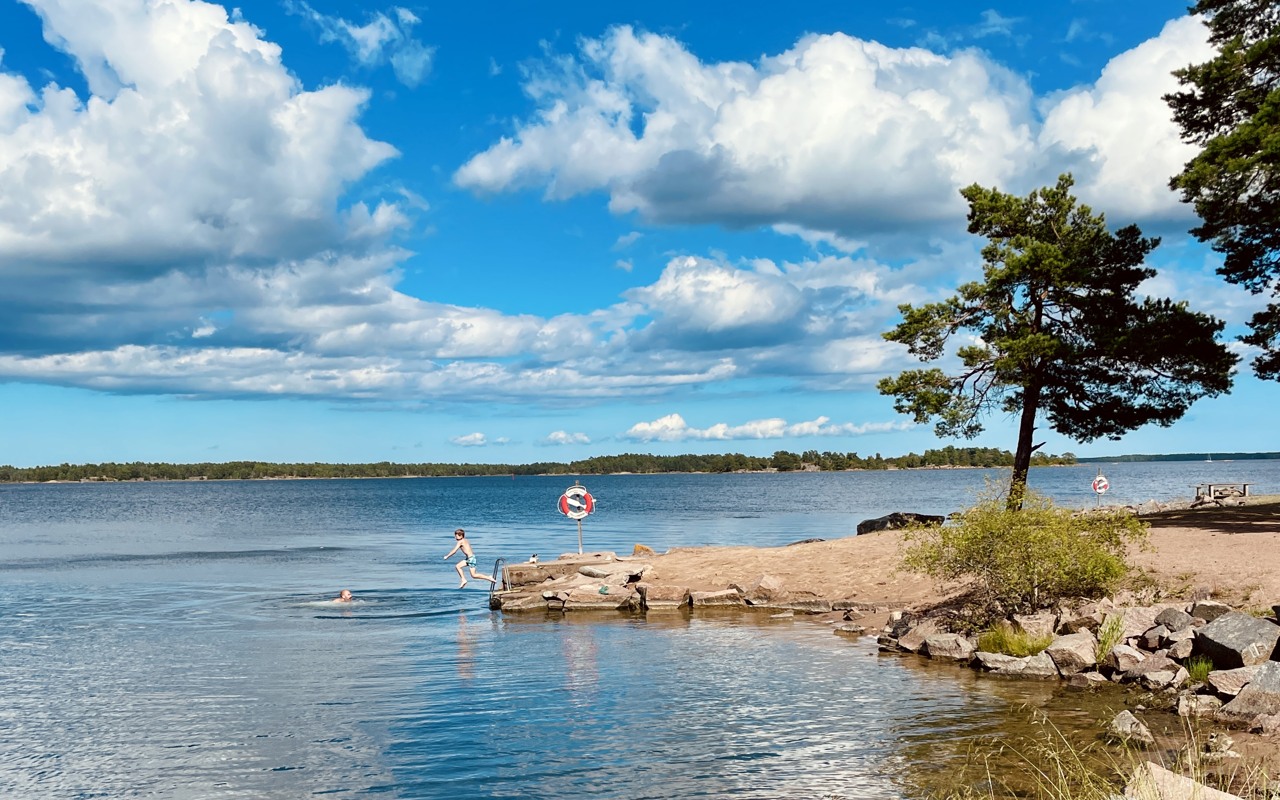 Ett barn hoppar i vattnet från en klippa vid badplatsen i Vånevik